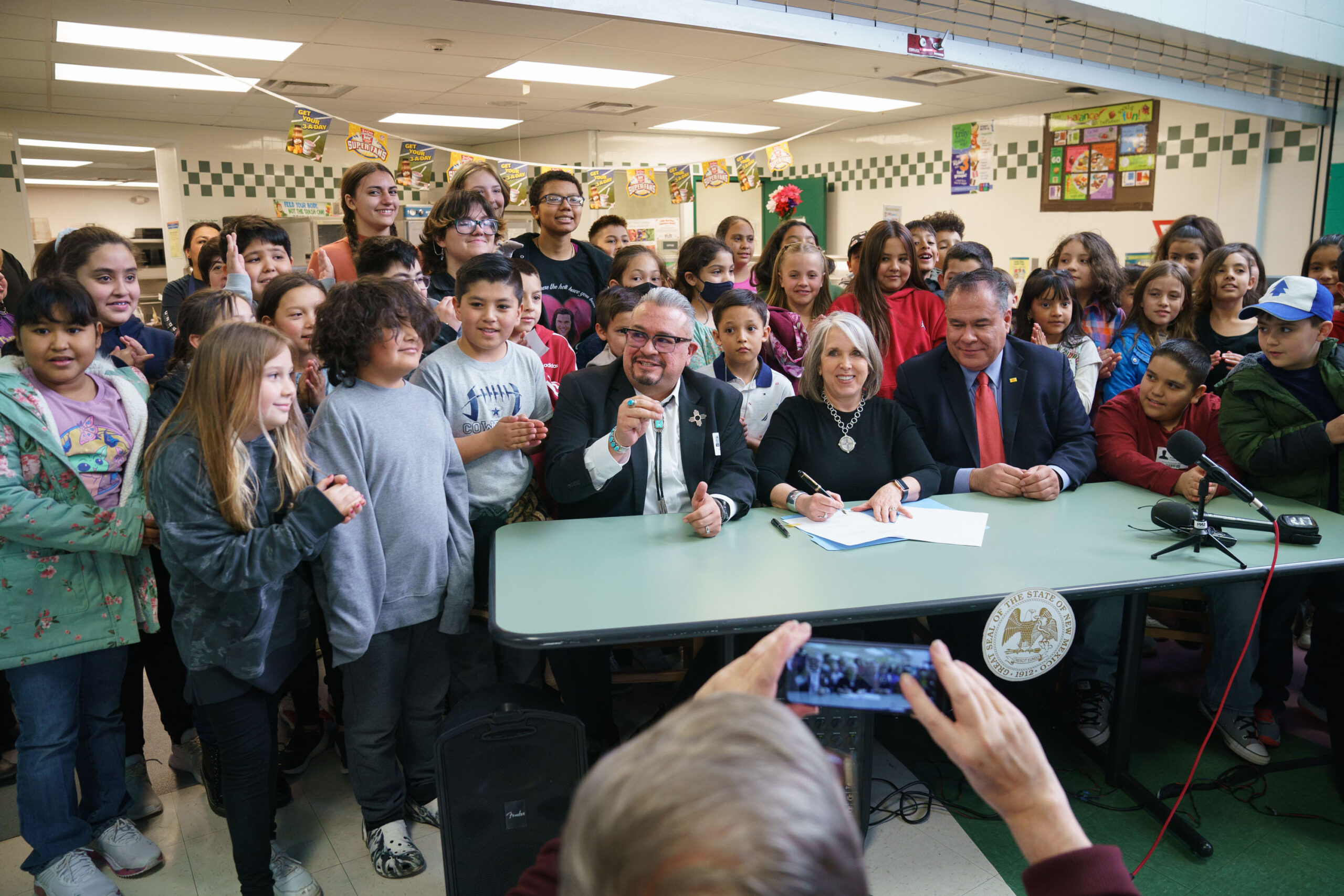 Governor Michelle Lujan Grisham signs Senate Bill 4 with sponsors Senator Michael Padilla and Senator Leo Jaramillo, at Pinon Elementary School in Santa Fe, new Mexico, March 27, 2023. 